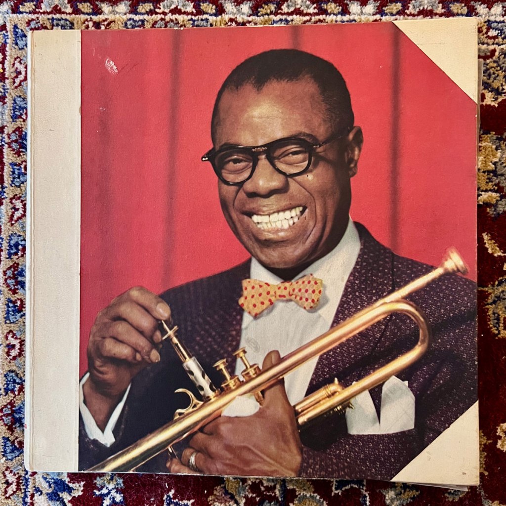 Leende Louis Armstrong med trumpet i handen.